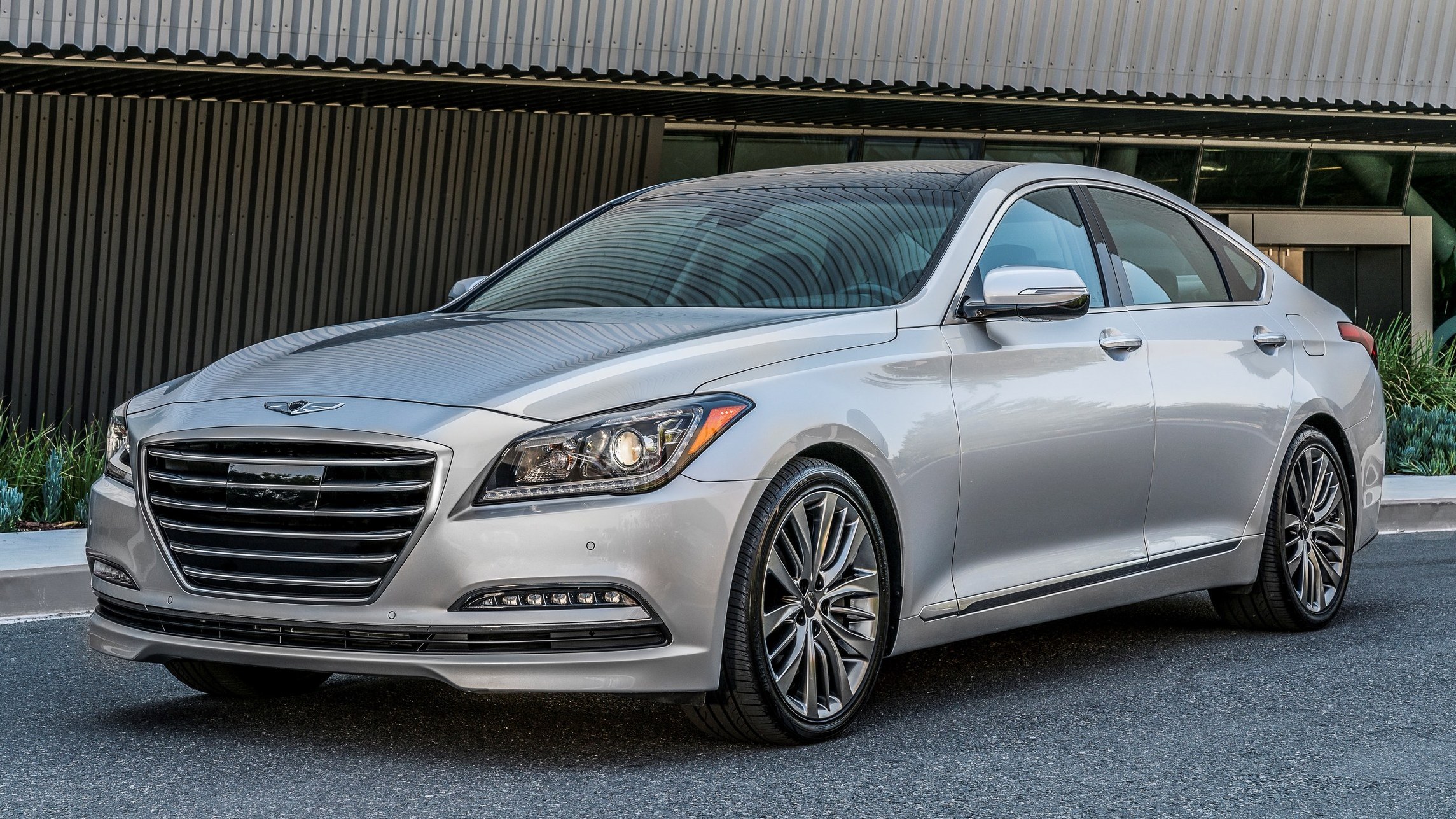 Silver 2017 Genesis G80 sedan parked in front of a modern building