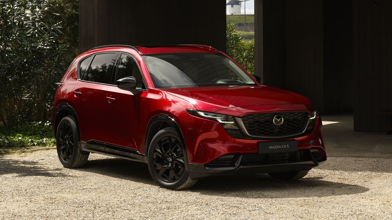 Red Mazda CX-5 third generation, front three-quarter view, parked on gravel