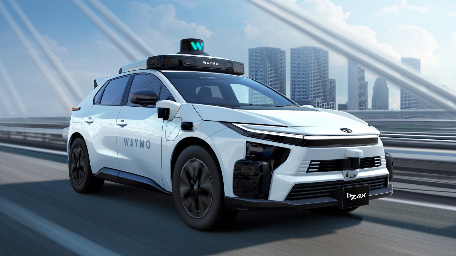 White Toyota bZ4X robotaxi with Waymo roof sensor pod driving on an elevated highway with a city skyline behind
