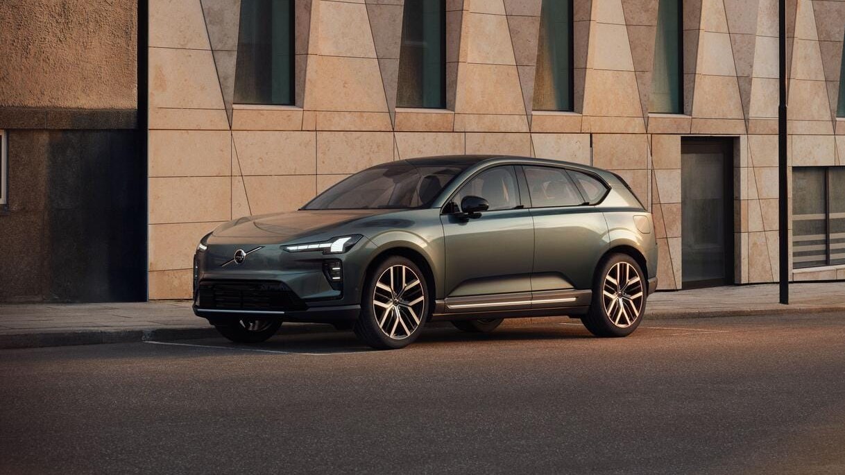 Volvo EX60 electric SUV parked on a city street in front of a stone building
