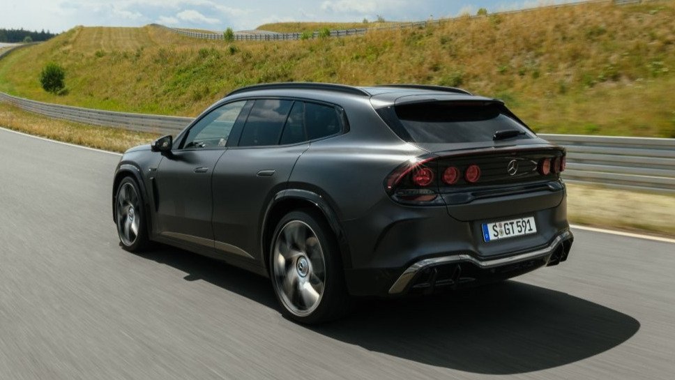 Dark gray Mercedes-AMG GT SUV driving on a test track, rear three-quarter view