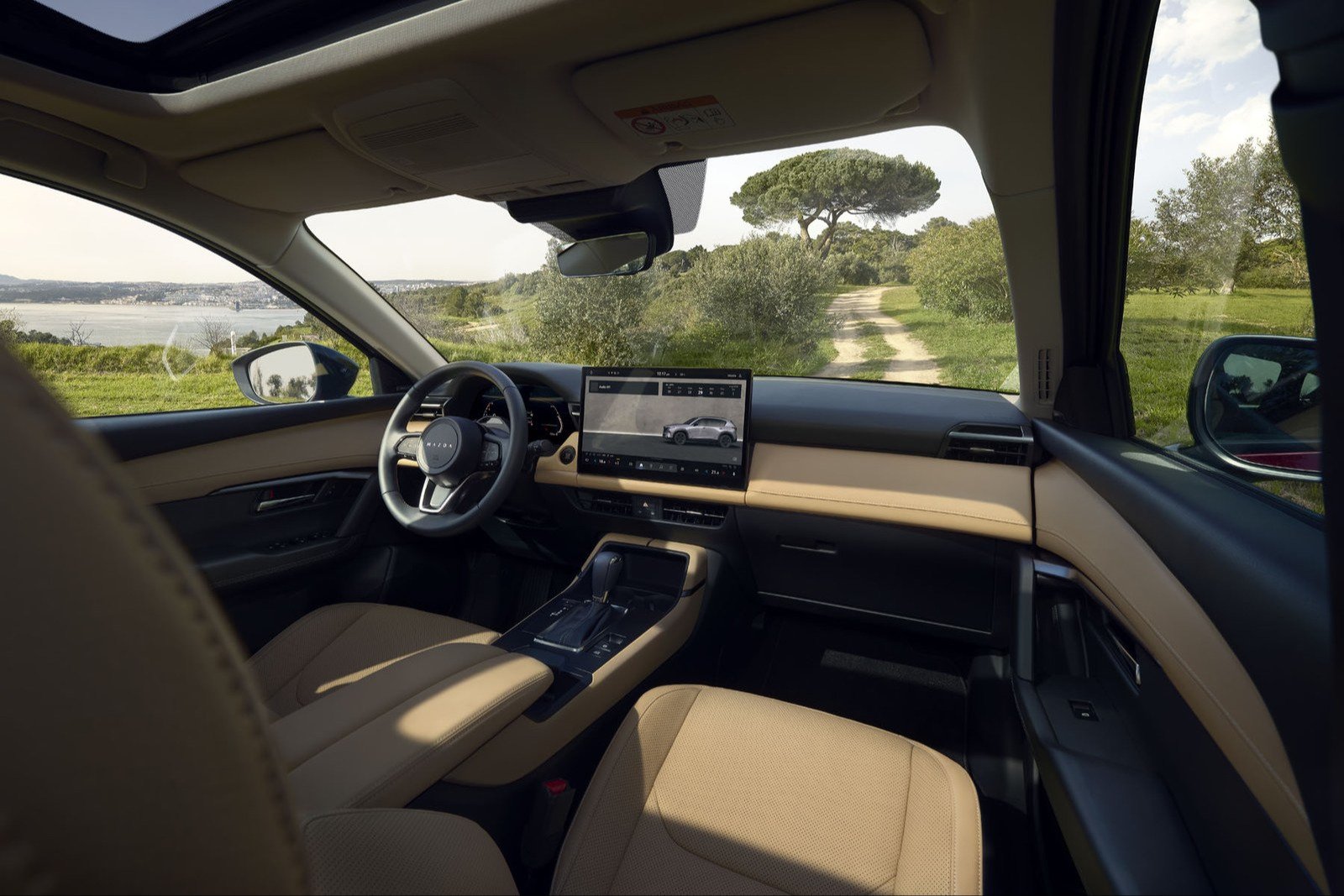 Mazda CX-5 cabin with tan leather seats, panoramic roof and center touchscreen