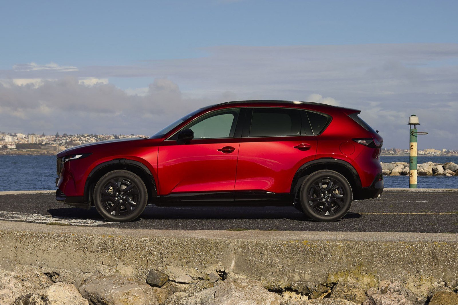 Red Mazda CX-5 in side profile by the sea