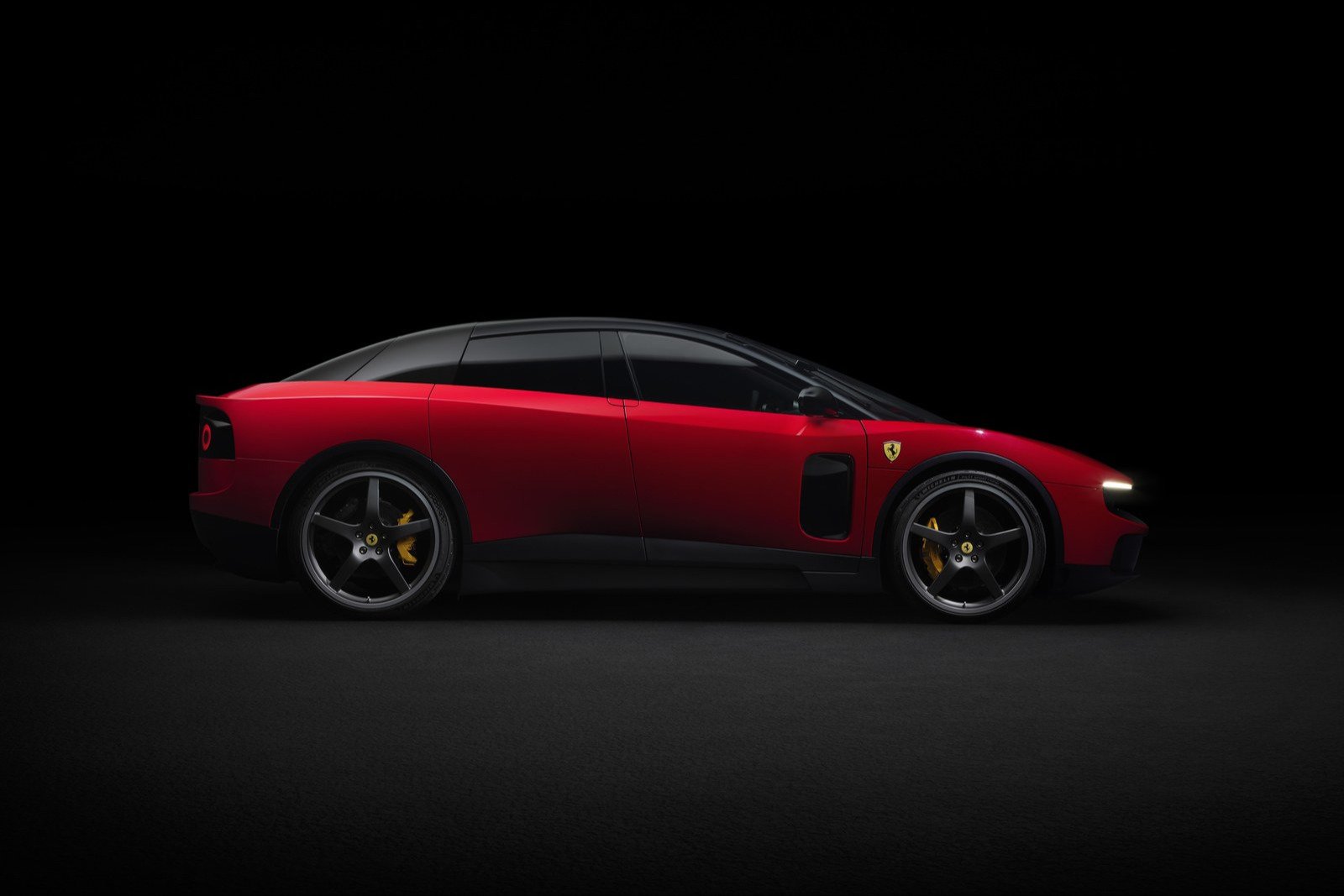 Side profile of a red Ferrari Luce showing its four doors