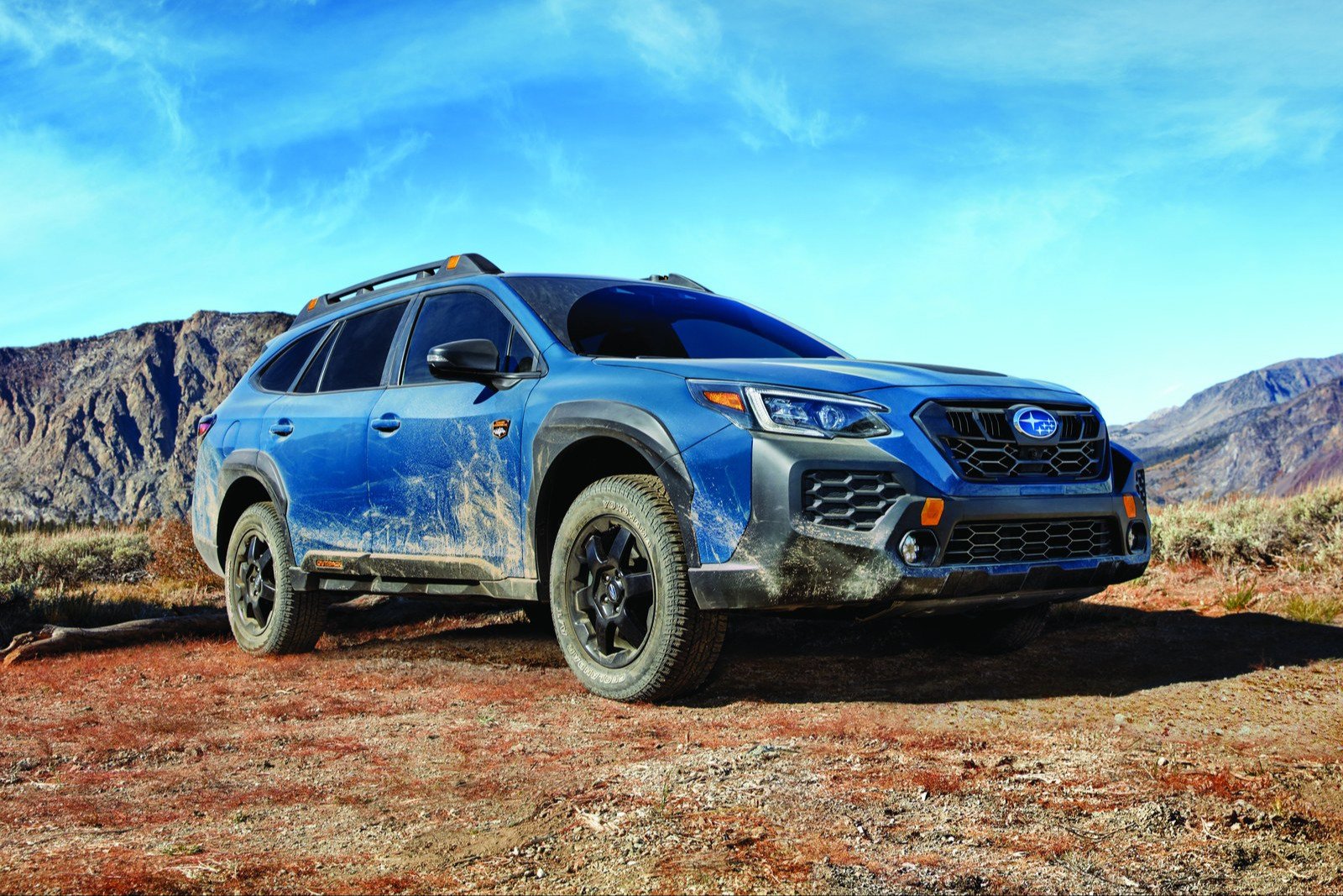 Blue 2025 Subaru Outback Wilderness, the last wagon-based generation, on a dirt plateau