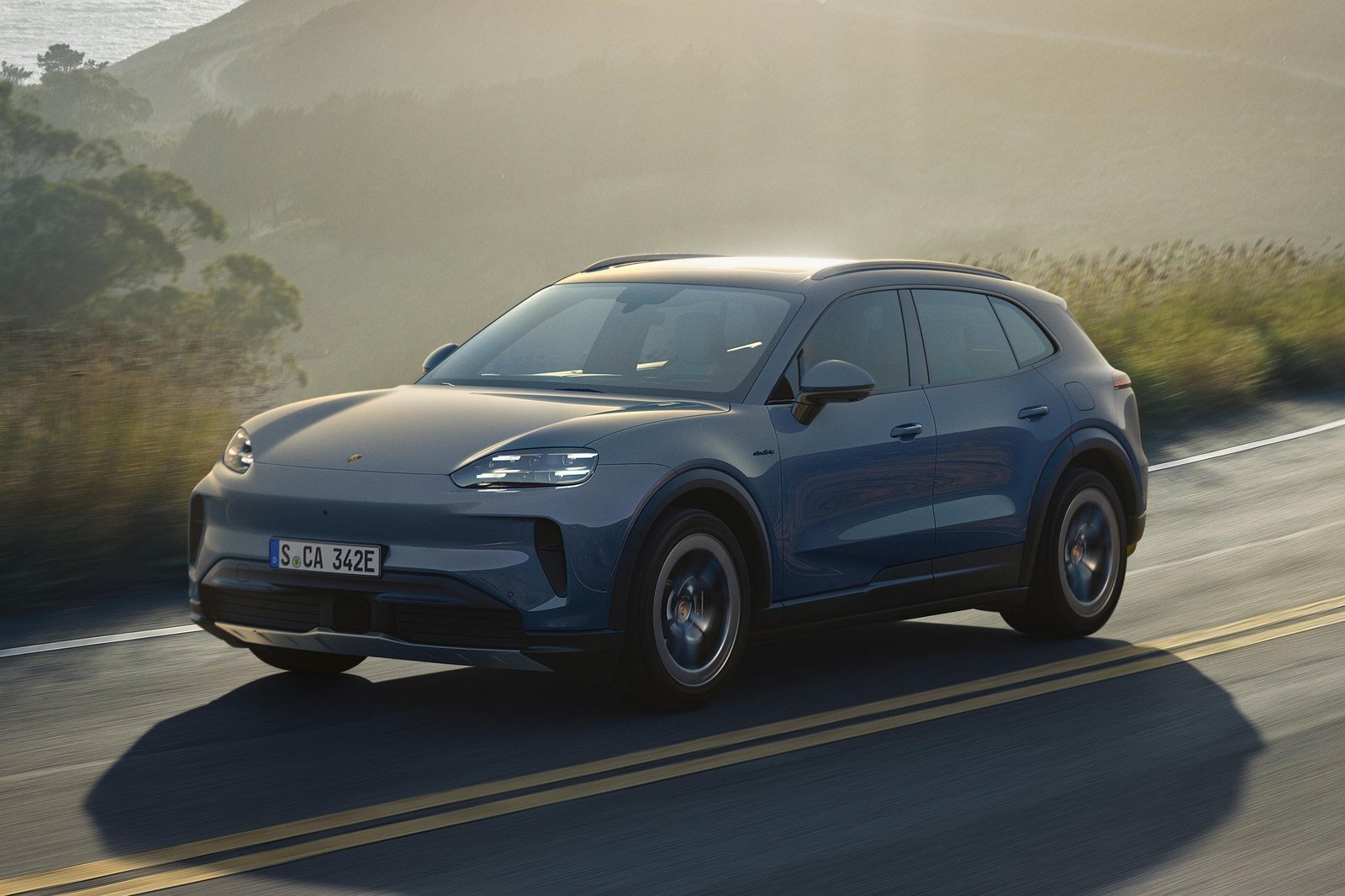Gray Porsche Cayenne S Electric driving on a coastal mountain road