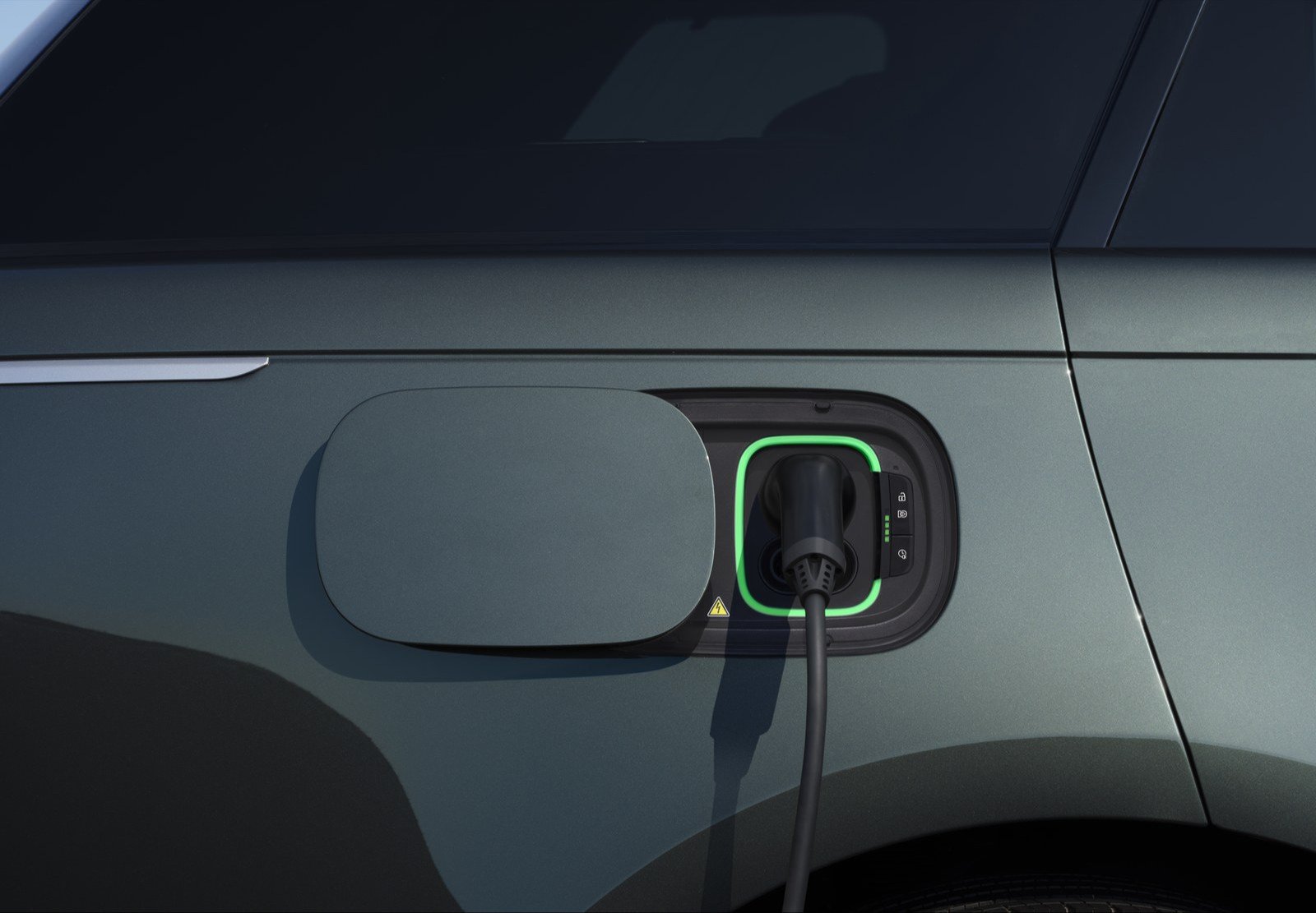 Charging cable plugged into the illuminated charge port of a Range Rover Electric