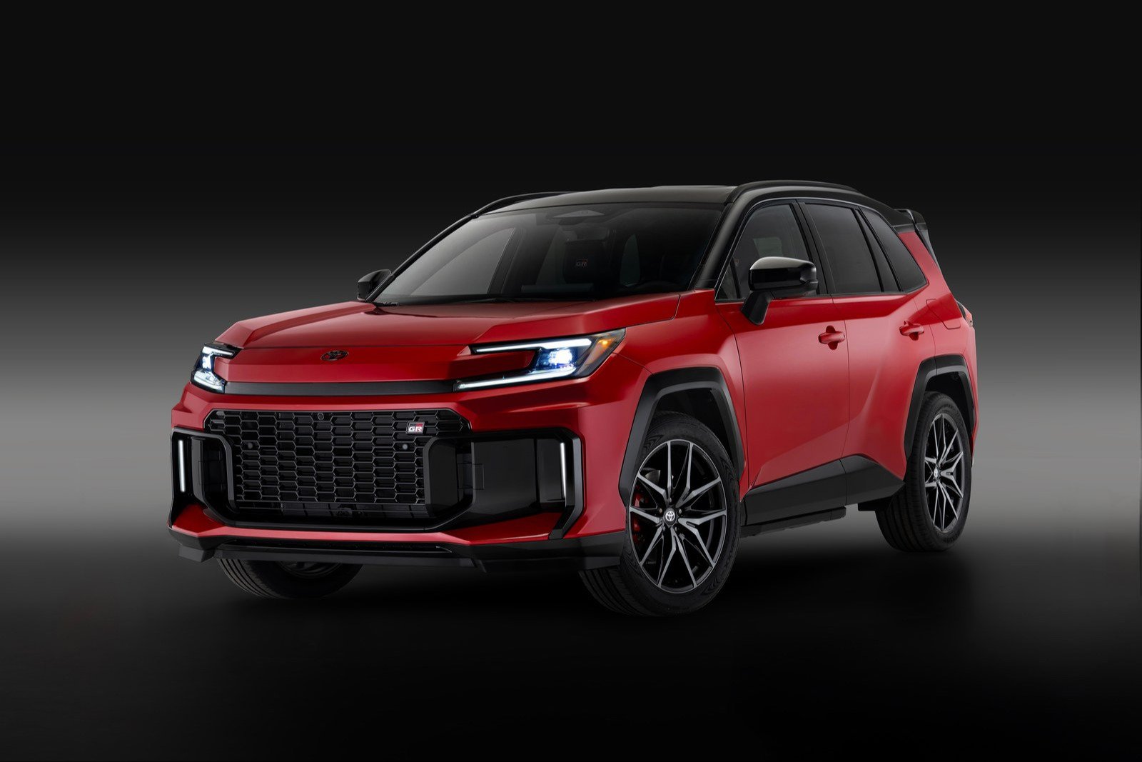 Red 2026 Toyota RAV4 Plug-in Hybrid GR Sport with black roof in a dark studio